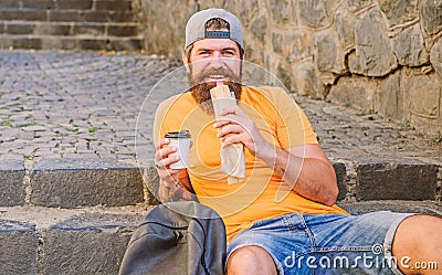 Junk food. Guy eating hot dog. Man bearded enjoy quick snack and drink paper cup. Street food so good. Urban lifestyle Stock Photo