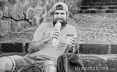 Junk food. Guy eating hot dog. Man bearded enjoy quick snack and drink paper cup. Street food so good. Urban lifestyle Stock Photo