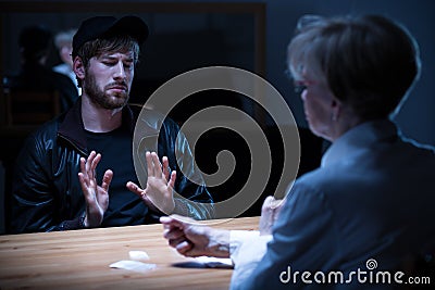 Junkie man interrogated by policewoman Stock Photo