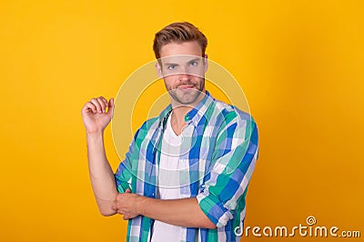 Just cool dude. Handsome dude portrait. Young man roll up shirt sleeves. Serious guy yellow background Stock Photo