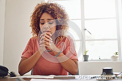 She just doesnt know what to do next. an overwhelmed young designer looking stressed while sitting at her desk in the Stock Photo