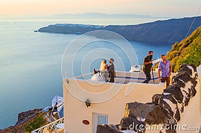 Just married couple on the rooftop Santorini Caldera cliff face Greece Editorial Stock Photo