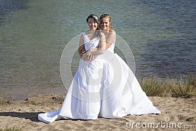 Just married happy lesbian couple in white dress embrace near sm Stock Photo