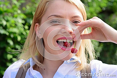 Just one more reason to smile. Pretty woman with happy smile. Happy woman hold cherry berries in healthy teeth. Sensual Stock Photo