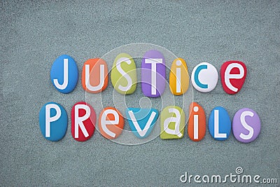 Justice Prevails, creative slogan composed with multi colored stone letters over green sand Stock Photo