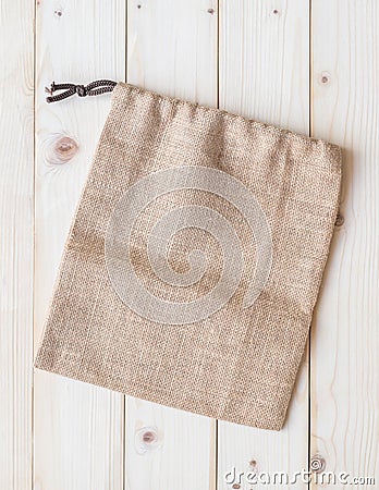 Jute hessian canvas tote bag with drawstring, mockup of small eco sack made from natural hemp burlap flat lay on white wood Stock Photo