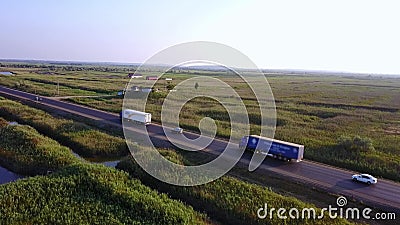 4K ANTENNE: Het vliegen hoog boven container semi vrachtwagen die goederen op bezige weg over het land in mooi vervoeren stock footage 4K ANTENNE: Het vliegen hoog boven container semi vrachtwagen die goederen op bezige weg over het land in mooi vervoeren stock footage