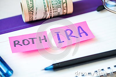 401k ira roth on pieces of colorful paper dollars on table. Pension concept. Retirement plans Stock Photo