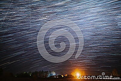 5k Night Starry Sky Above Village. Sky Background Over Rural Countryside Landscape. Meteors Cross Dark Blue Sky. Amazing Stock Photo