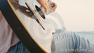 4K Schließen Sie oben von der langen Haarfrau, die Akustikgitarre am Strand mit leichtem Wind während der Sonnenuntergangzeit spi stock footage 4K Schließen Sie oben von der langen Haarfrau, die Akustikgitarre am Strand mit leichtem Wind während der Sonnenuntergangzeit spi stock footage