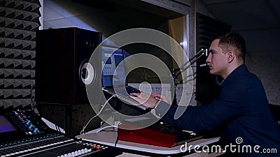4K Young sound engineer in recording studio using laptop at the mixing desk Stock Photo