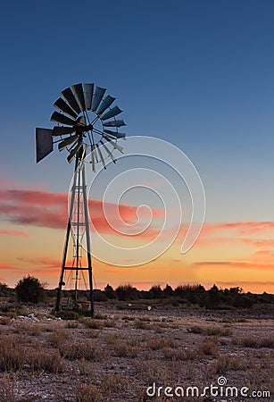 Kalahati sunset with trees grass windmill and blue sky Stock Photo