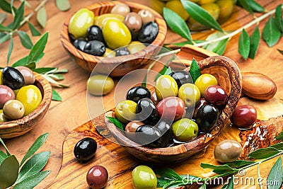 Kalamata, green and black olives in the wooden bowls. Food background. Top view Stock Photo