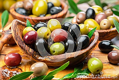 Kalamata, green and black olives in the wooden plate. Food background Stock Photo