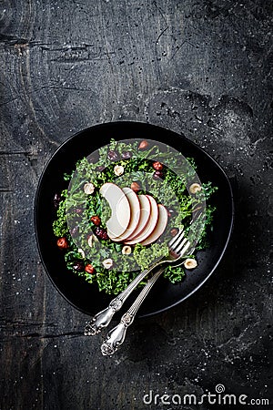 Kale salad with dried cranberry, hazelnuts and sliced apple. Stock Photo