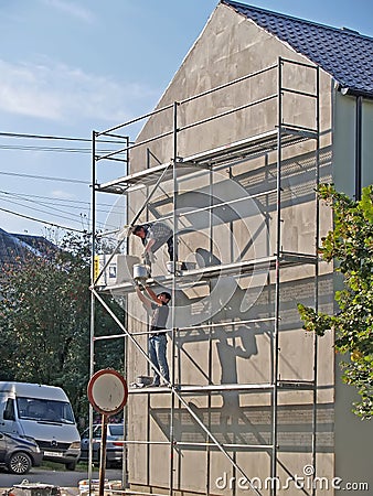 KALININGRAD REGION, RUSSIA. Guest workers repair the facade of the building Editorial Stock Photo