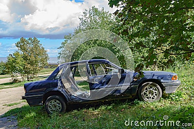 Wrecked old car. Abandoned car. Stolen car. Mitsubishi blue. Passenger car Editorial Stock Photo