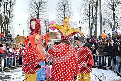 KALININGRAD, RUSSIA. Buffoons stand against the background of an effigy. The celebration of Maslenitsa in the park Editorial Stock Photo