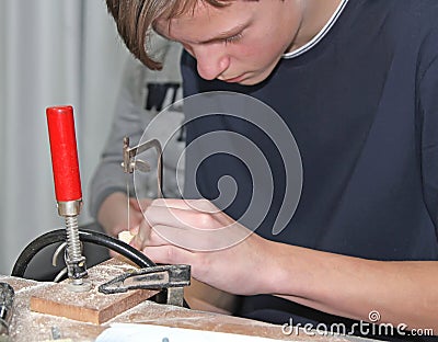 A teenager saws a wooden detail with a lobzer. Wood Processing Master Class Editorial Stock Photo