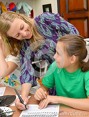 KALININGRAD, RUSSIA. The joyful teacher and the schoolgirl on occupation a calligraphy in children`s studio Editorial Stock Photo