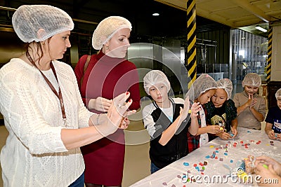 A joint lesson for children and parents in sculpting figures from a pastry mastic. Children`s workshop at the chocolate factory Editorial Stock Photo