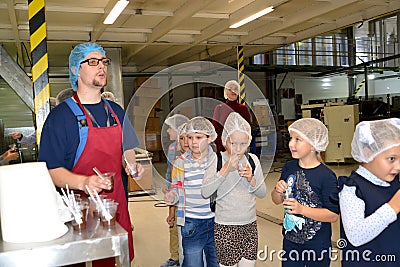 KALININGRAD, RUSSIA. Male master hands out chocolate mass to children for tasting. Children `s tour to the Belgostar chocolate fa Editorial Stock Photo