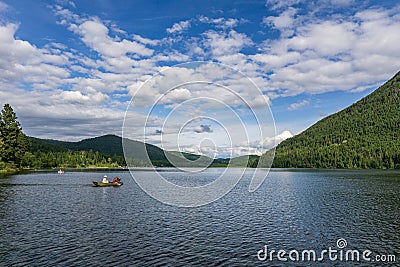 KAMLOOPS, CANADA - AUGUST 4, 2020: people in the boat Paul Lake Provincial Park with blue sky and white clouds Editorial Stock Photo