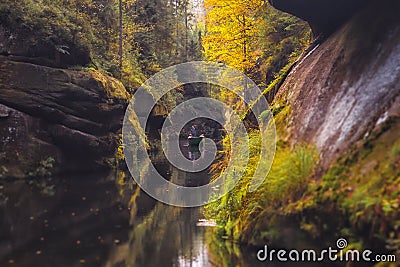 The Kamnitz Gorge - a boat with a ferryman and tourists on the river flowing through rocky ravine in Bohemian Switzerland, Czech R Stock Photo