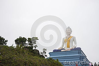 Kampot, Cambodia - 12 April 2018: Buddha statue in mist with people and green landscape. Religious place Editorial Stock Photo