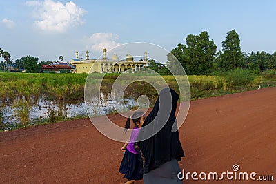 Kampot. Cambodia. Veiled Muslim woman walking in front of the mosque Editorial Stock Photo