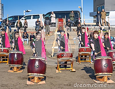 Music band of Japanese Wadaiko drums played by girls in happi on Enoshima Beach. Editorial Stock Photo