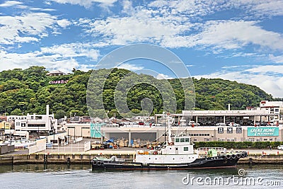 Tugboat moored in front of the DIY stores Cainz Home with the Kurihama Flower park in background. Editorial Stock Photo