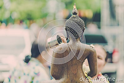 KANCHANABURI THAILAND - APRIL 17 : Unidentified people Shower the monk sculpture in Songkran festival on April 17,2018 at Wat Editorial Stock Photo