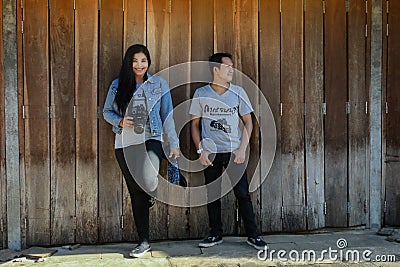 Young standing poses photographed with old wooden doors. Editorial Stock Photo