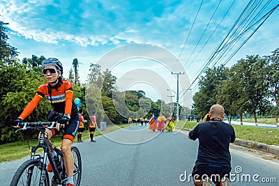 KANCHANABURI, THAILAND-OCTOBER 6,2019 : Back view of unidentified sport photographer sit to take a picture marathon runners in Editorial Stock Photo