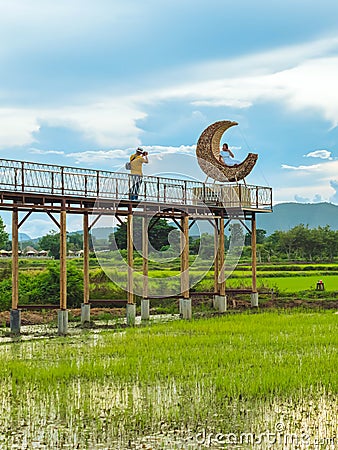 KANCHANABURI-THAILAND, SEPTEMBER 13, 2020 : Happy young couple take photo with crescent moon chair made of rattan for relaxation Editorial Stock Photo