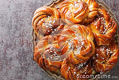 Kanelbullar or Kanelbulle is a traditional Swedish cinnamon buns flavored with cinnamon and cardamom spices and topped with pearl Stock Photo
