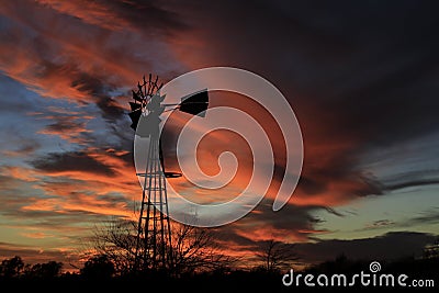 Kansas Awesome Sunset with colorful clouds, and a farm Windmill silhouette . Stock Photo