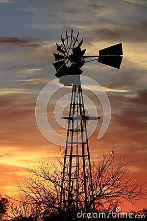 Kansas Awesome Sunset with colorful clouds, and a farm Windmill silhouette . Stock Photo