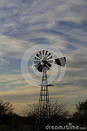 Kansas Awesome Sunset with colorful clouds, and a farm Windmill silhouette . Stock Photo