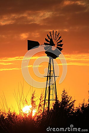 Kansas Blazing orange and yellow sky with a Windmill silhouette Stock Photo