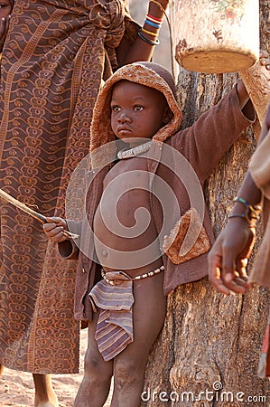 KAOKOVELD, NAMIBIA - OKT 13, 2016: Unidentified Himba boy in a small village. The child is helping protecting the cows. Editorial Stock Photo