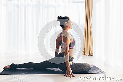 Kapotasana. Beautiful yoga woman practice in a training hall background. Stock Photo