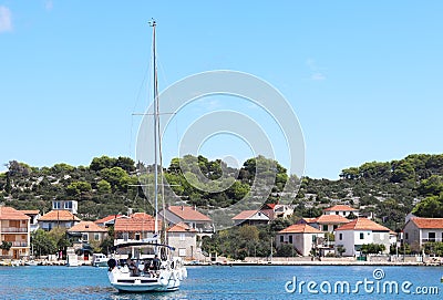 Kaprije, Croatia, Europe - 7 9 2018: Embankment of a small Croatian town in the Adriatic Sea. Sailing yacht on the background of t Editorial Stock Photo