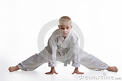 Karate boy tries to sit on a twine Stock Photo