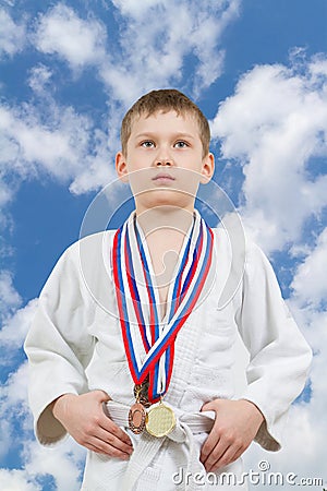 Karate boy in white kimono with medals fighting Stock Photo