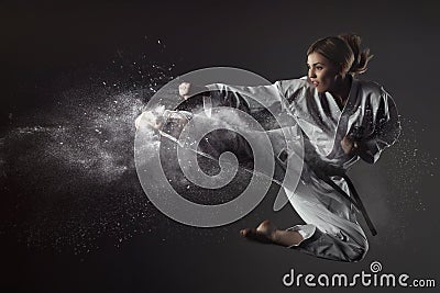 Karate girl bounces and makes a kick Stock Photo