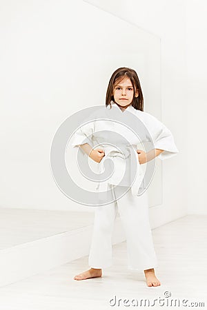Karate girl standing with hands on hips in gym Stock Photo
