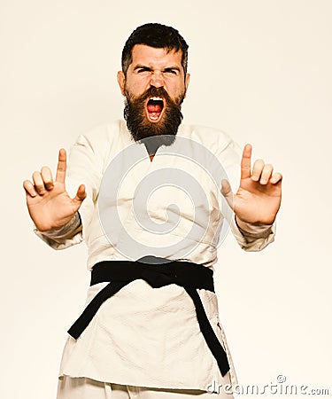 Karate man with angry face in uniform. Oriental sports concept. Jiu Jitsu master with black belt Stock Photo