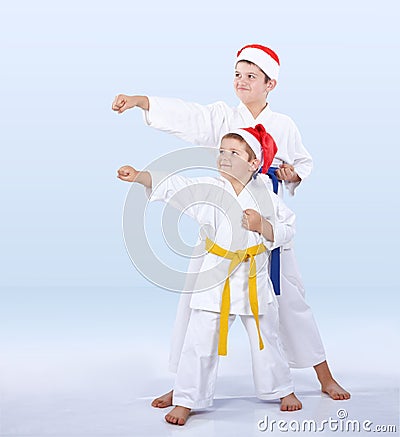 In karategi and hats Santa Claus the sportsmen are beating punch arm Stock Photo